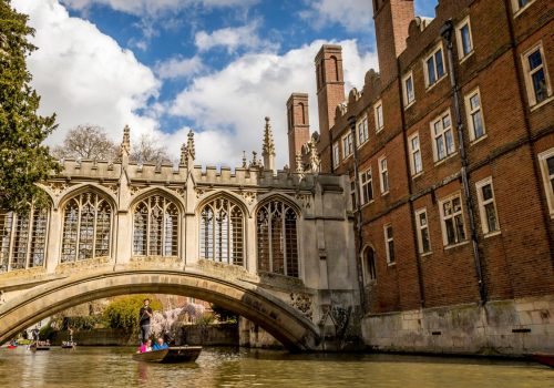 CAMBRIDGE, ENGLAND - April 17, 2016: People punting on the Cam River, passing under the Bridge of Sighs over the River at St Johns University College, Cambridge